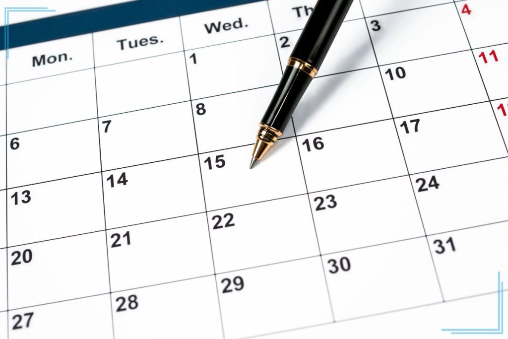 A calendar with a pen pointing at the 15th.